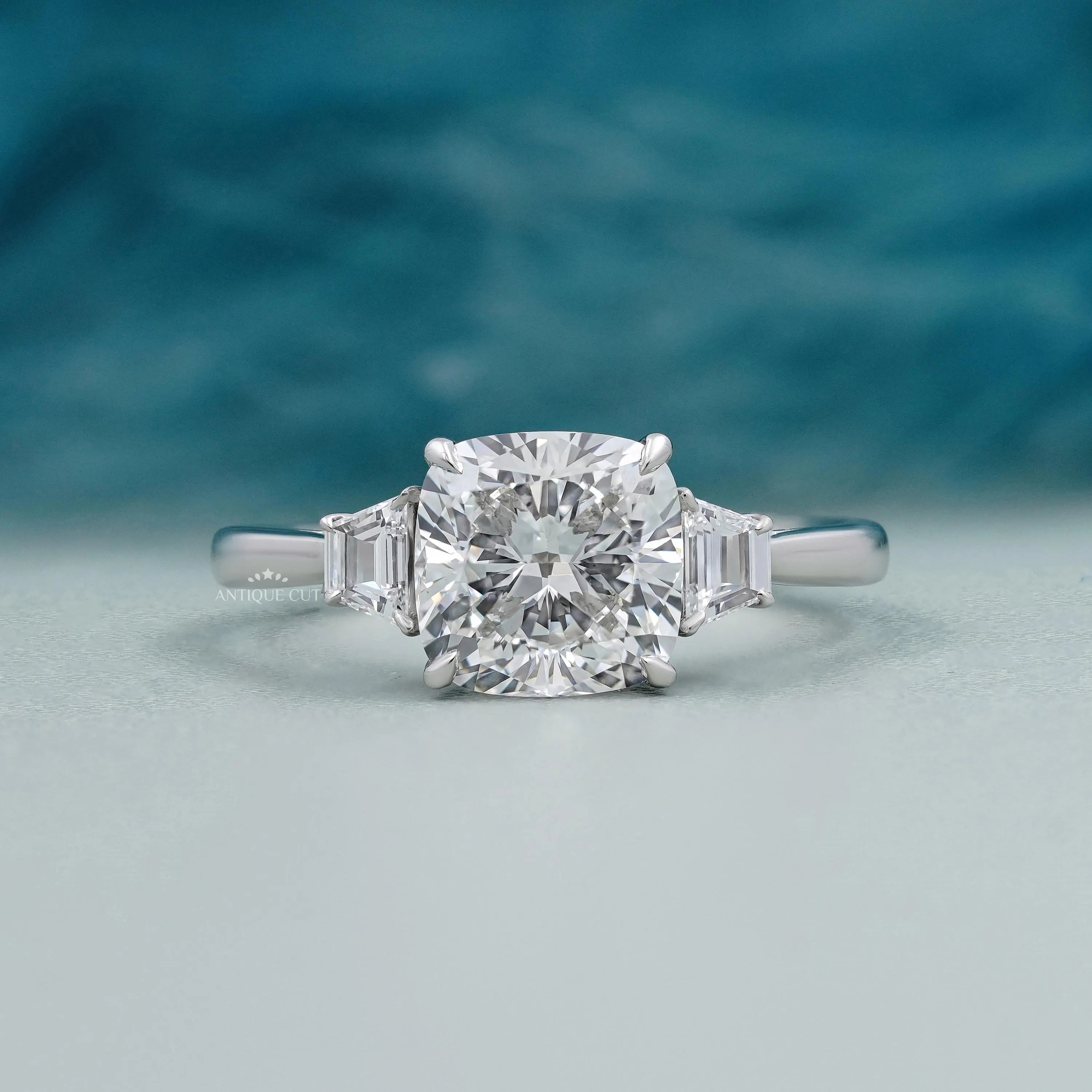 Cushion cut lab grown diamond engagement ring with tapered baguette side stones on white gold.