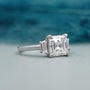 Square emerald cut three stone diamond engagement ring