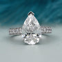 Pear cut engagement ring with pave band in white gold
