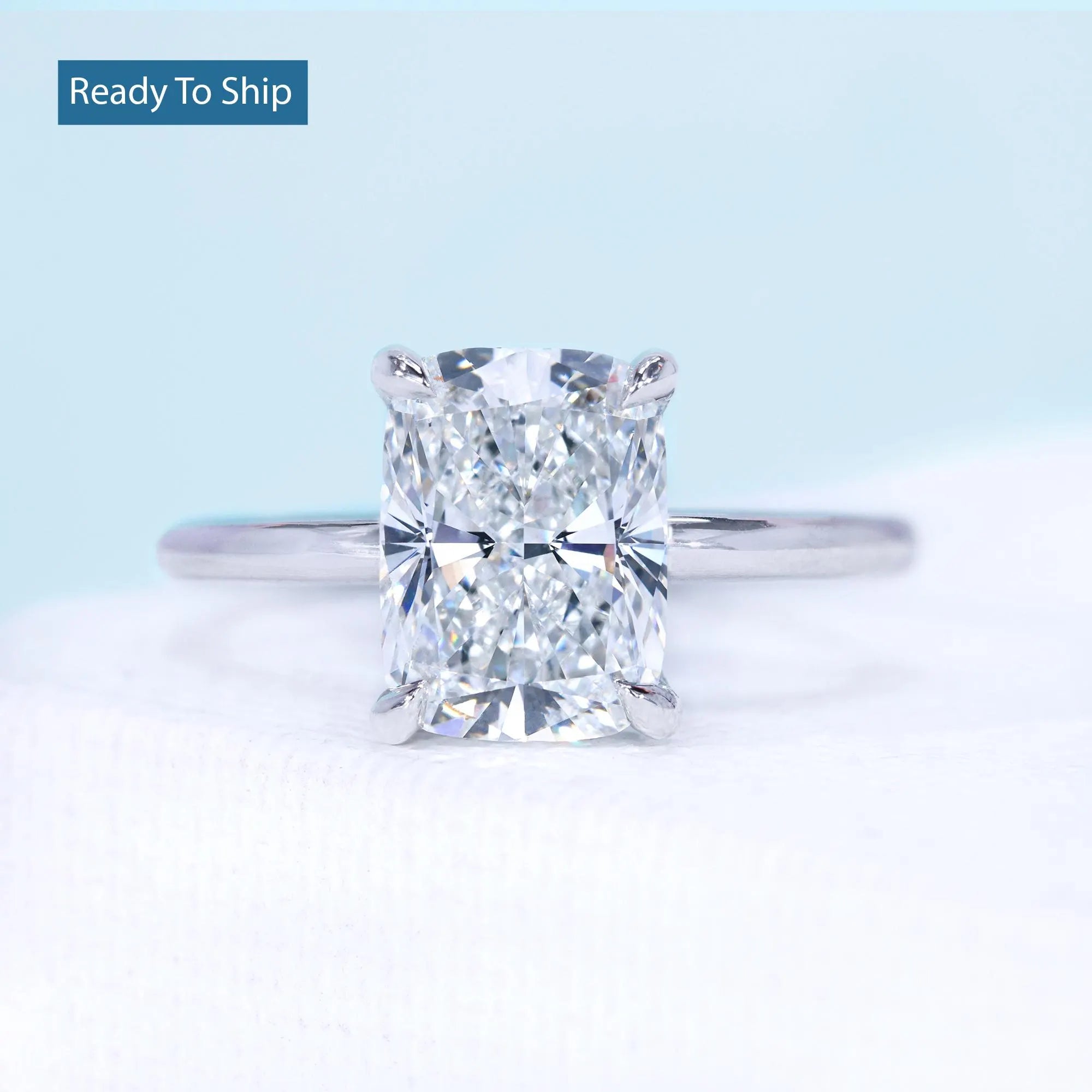 Cushion cut hidden halo engagement ring with solitaire diamond setting

