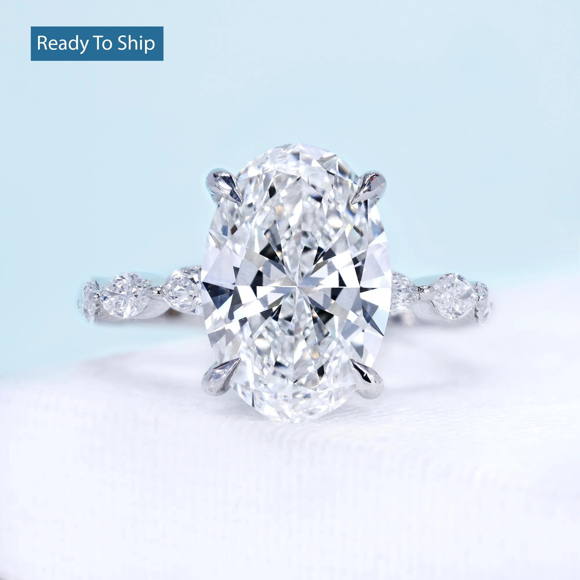 White gold oval diamond ring with marquise side stones and hidden halo setting
