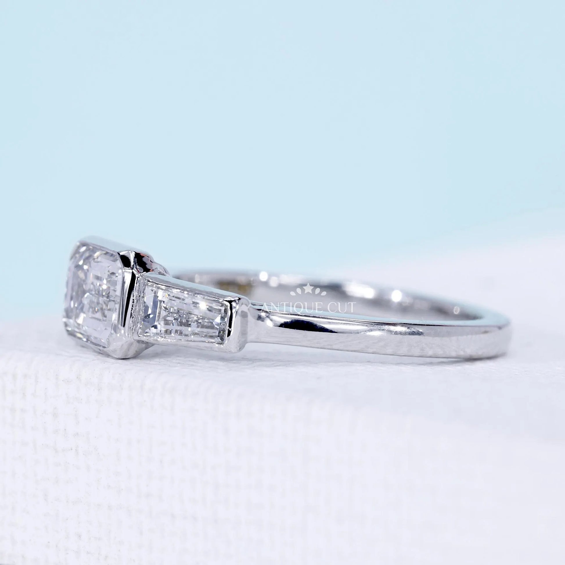 Lab grown emerald cut diamond ring with cathedral bezel setting
