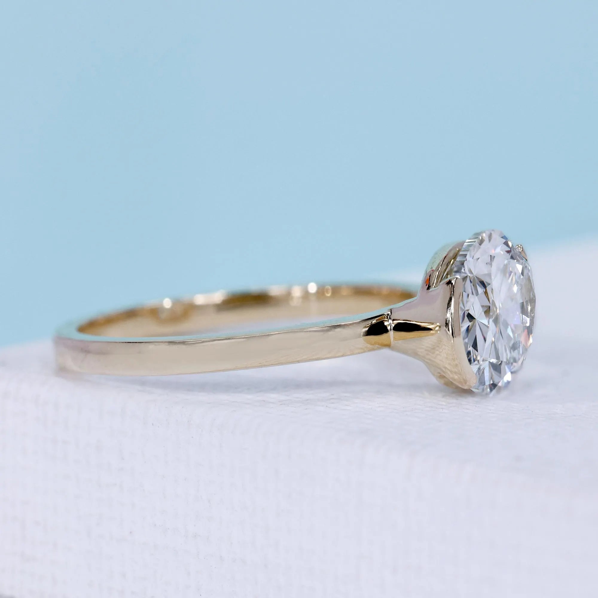 Yellow gold east west solitaire ring with lab grown oval diamond
