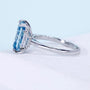 Radiant cut blue diamond three stone engagement ring with baguette sides