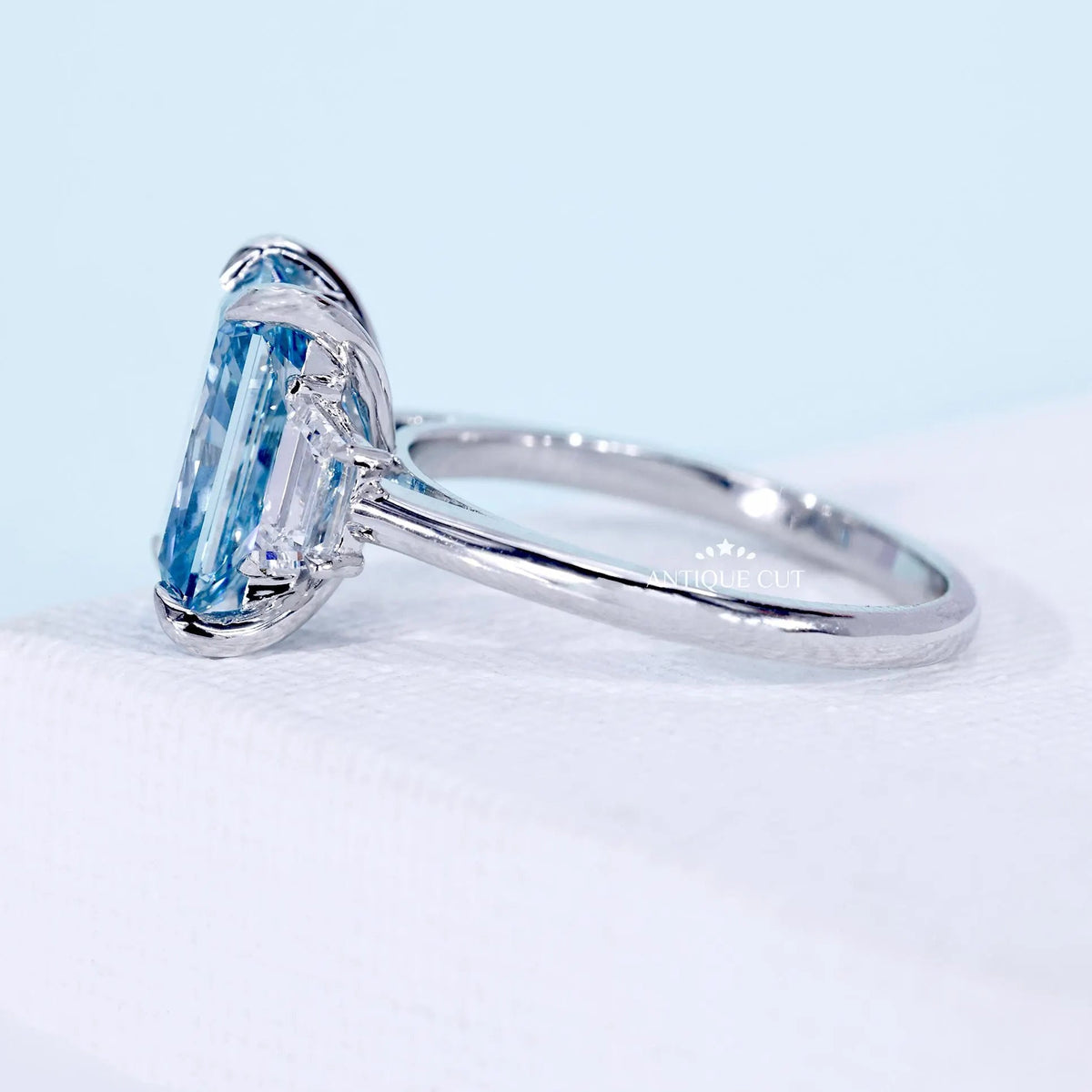 Radiant cut blue diamond three stone engagement ring with baguette sides