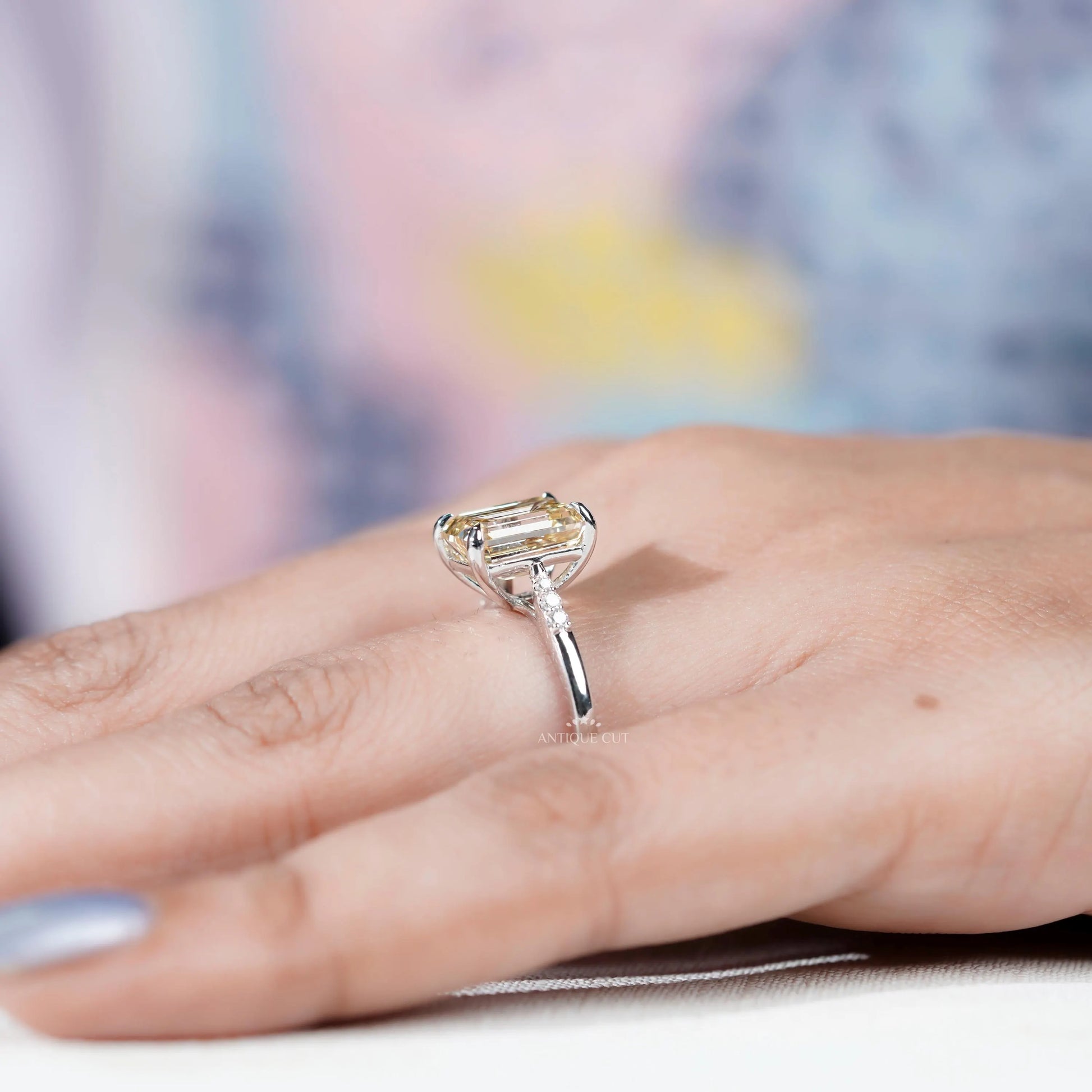 White gold engagement ring with Yellow Emerald Cut Diamond centerpiece.