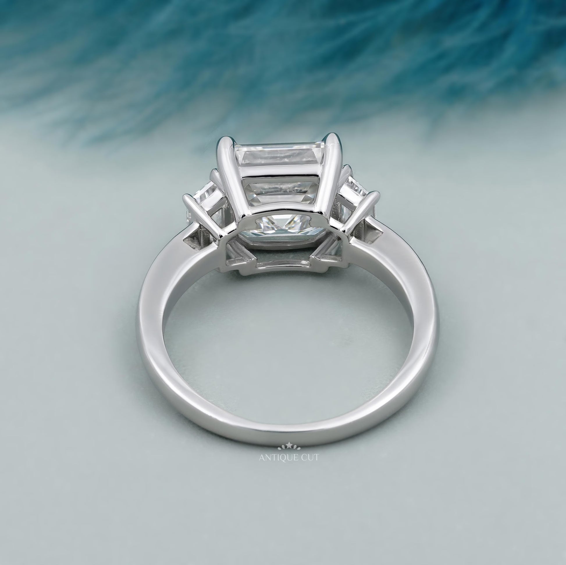Emerald cut diamond ring with tapered step cut side stones