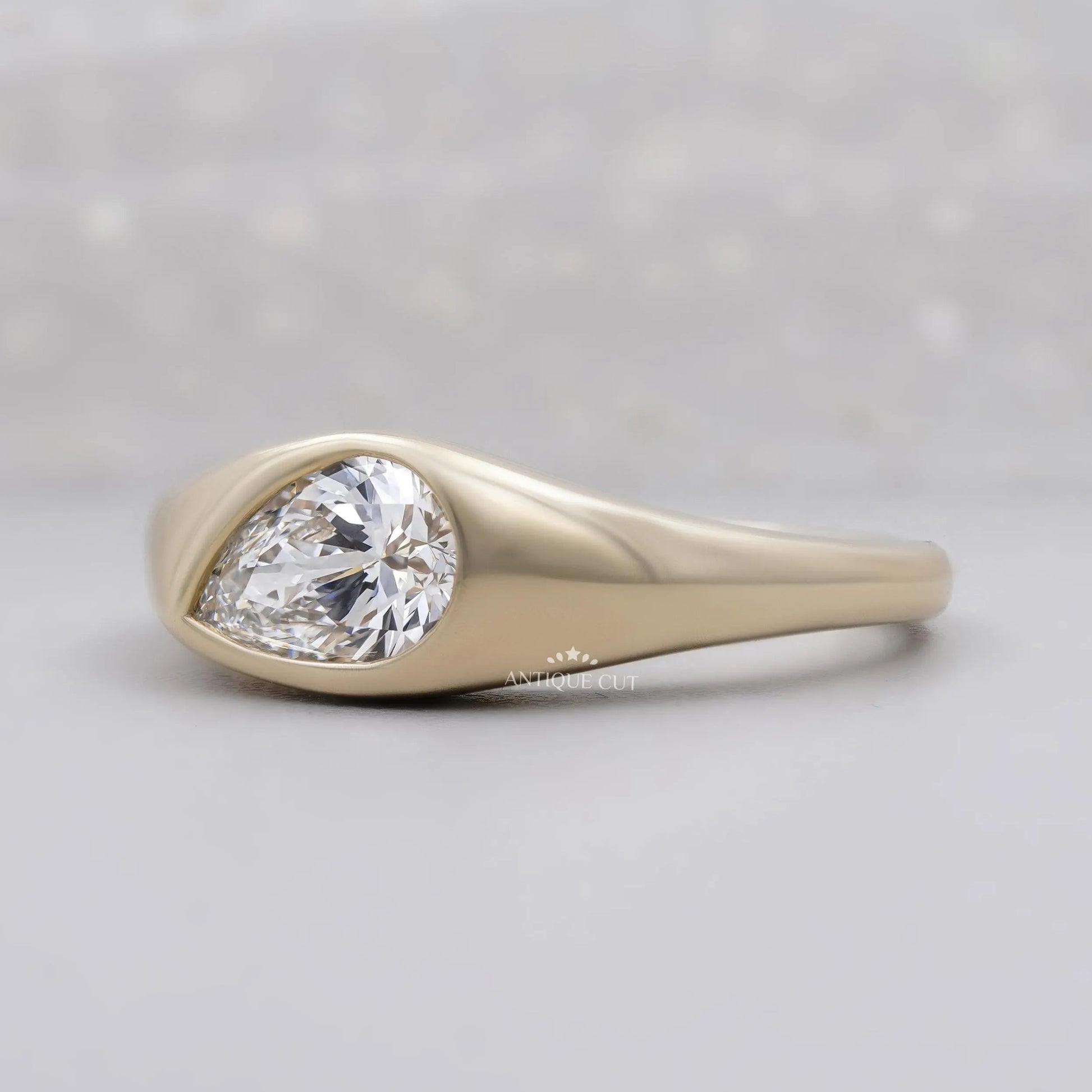 Yellow gold signet ring with sideways pear shaped diamond