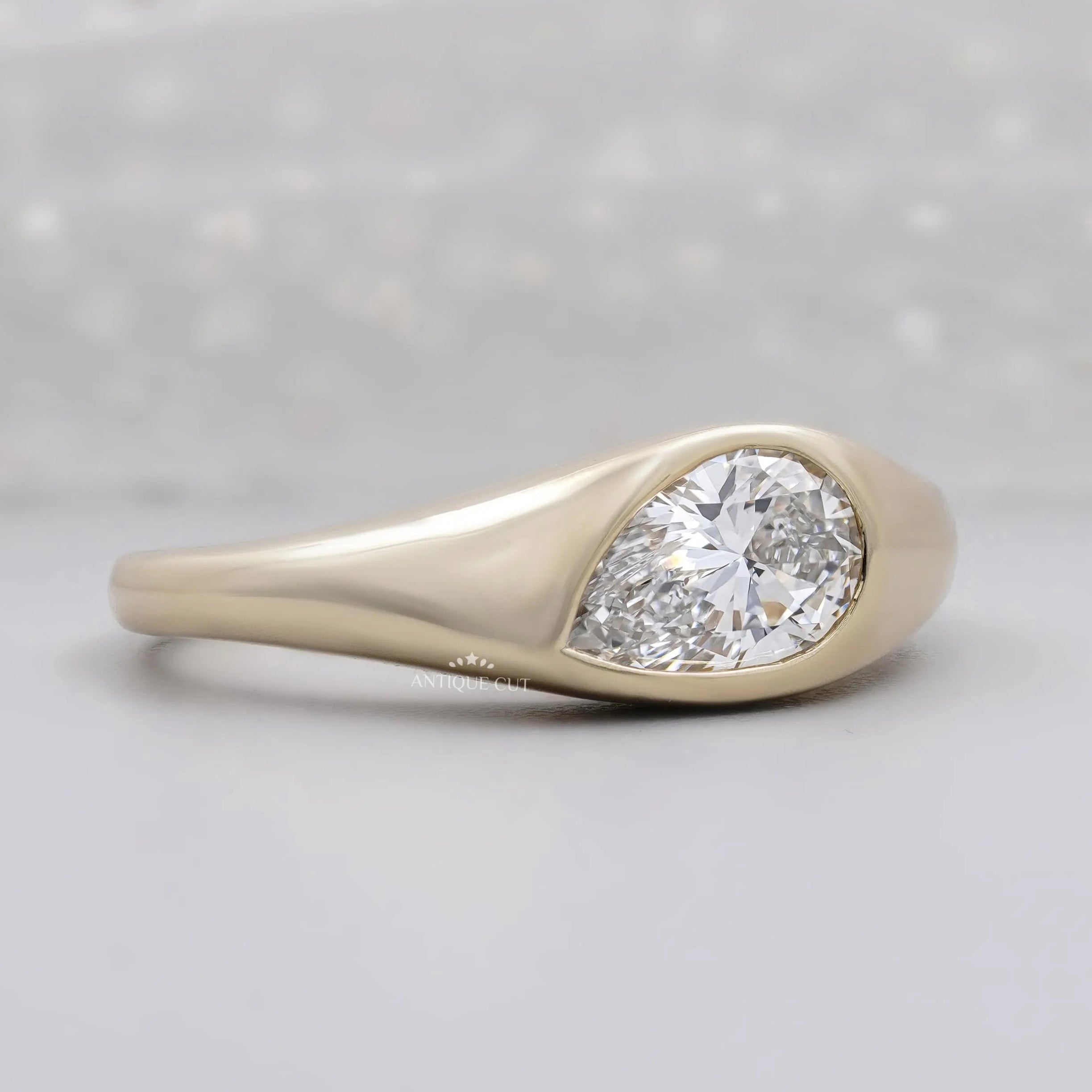 East west pear diamond ring with smooth bezel setting