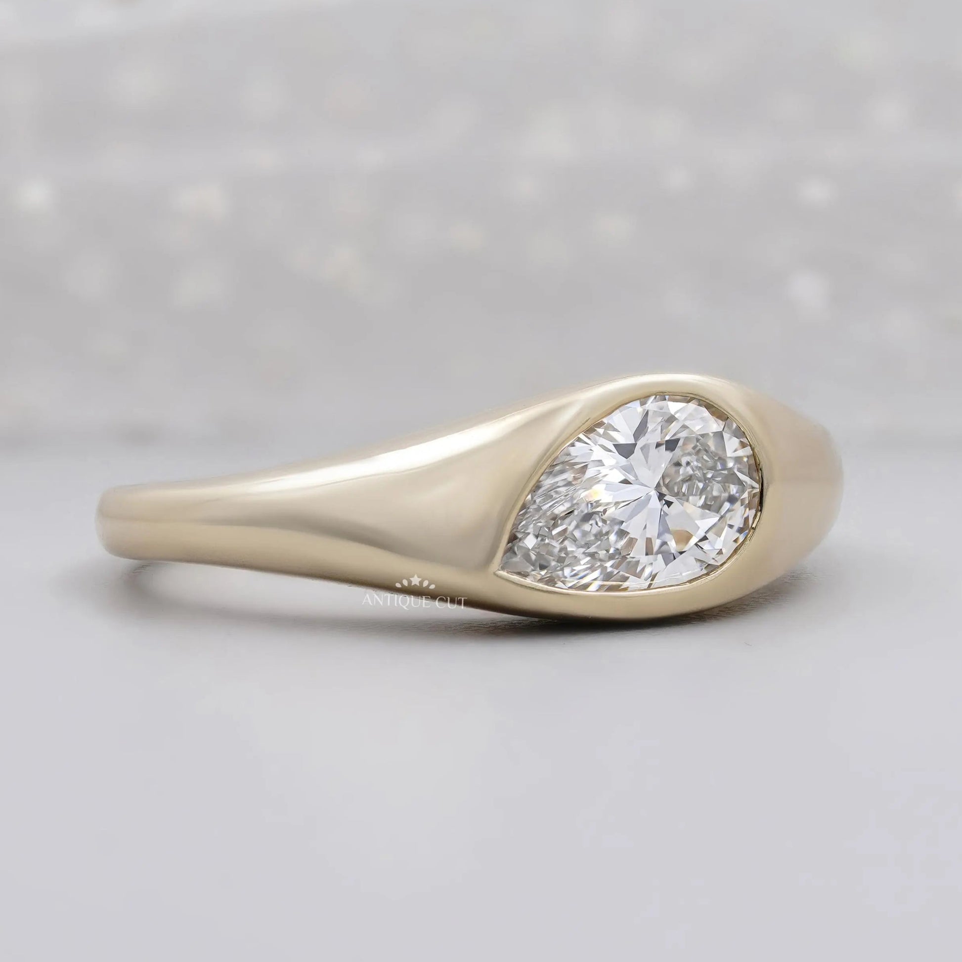 East west pear diamond ring with smooth bezel setting