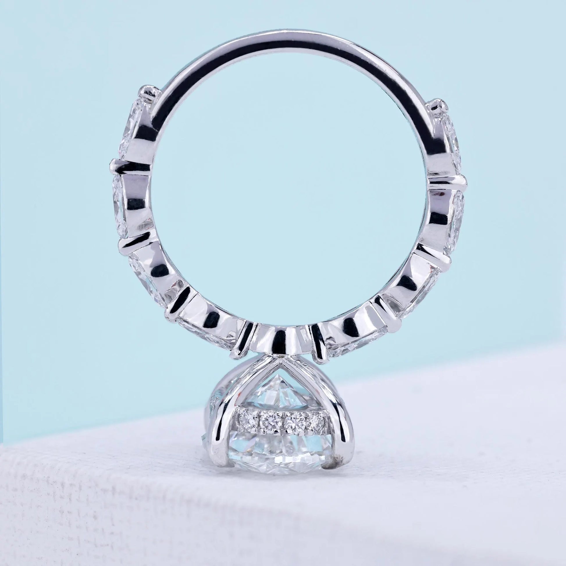 White gold oval solitaire ring with marquise pavé band detail

