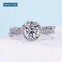 Floral halo engagement ring with round cut diamond and twisted pavé band
