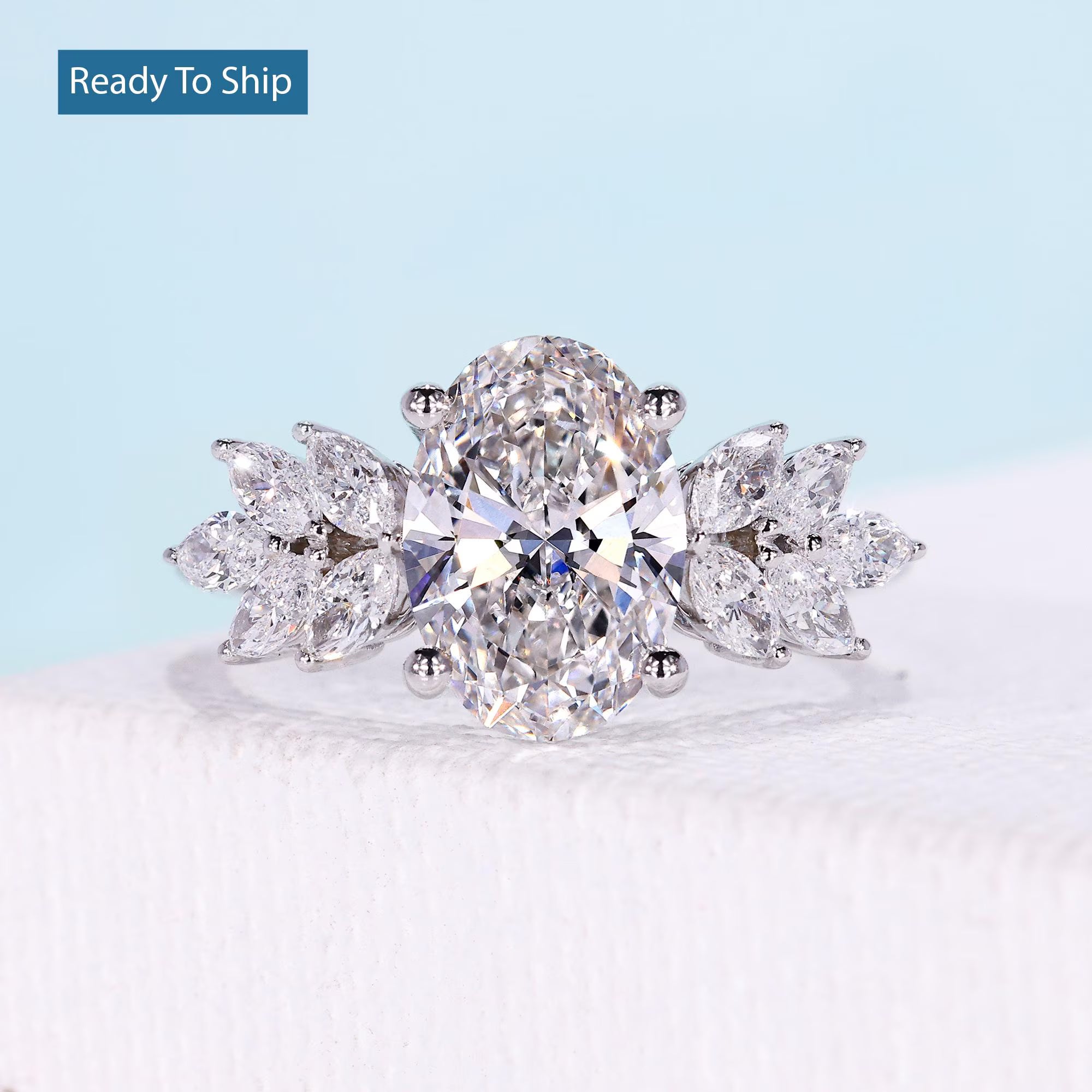 Oval cut diamond engagement ring with marquise floral side stones in white gold
