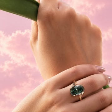 Antique Cut oval green stone engagement ring on hand