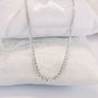 Diamond necklace on white cushions.