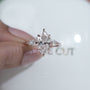 Rose gold ring with pear-shaped diamonds on a light gray background

vieo