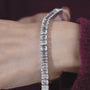 Silver bracelet with square-cut stones on a light gray background