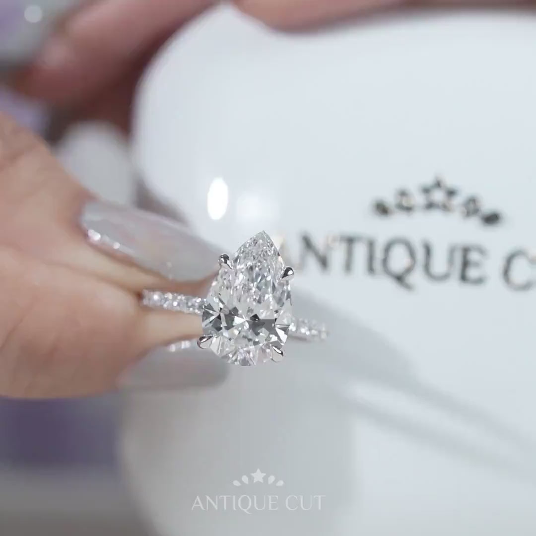 White gold pear diamond ring with round side accents
