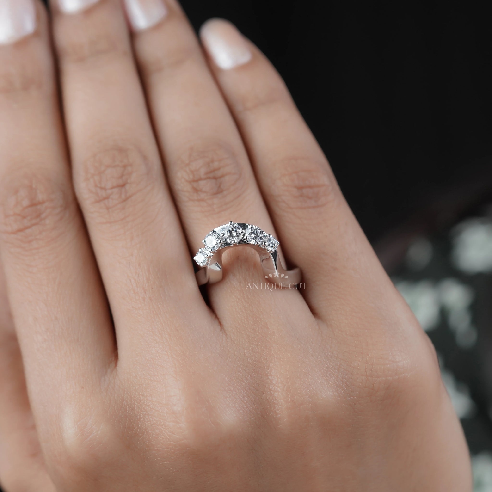 Five round cut diamonds set across a curved white gold band