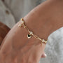 Gold designer charm bracelet featuring diamond heart, lock and key charm details