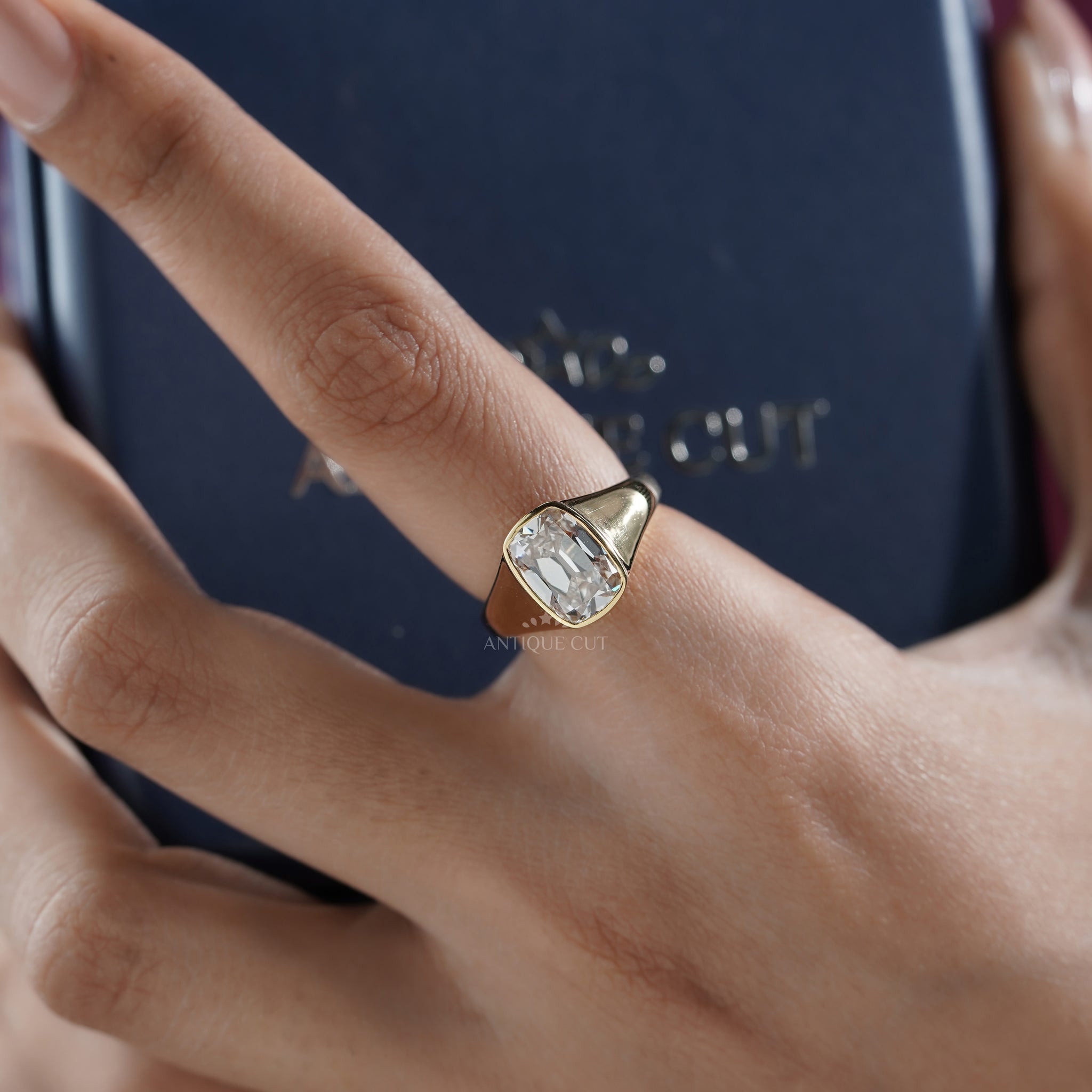 Cushion cut diamond bezel engagement ring with yellow gold band