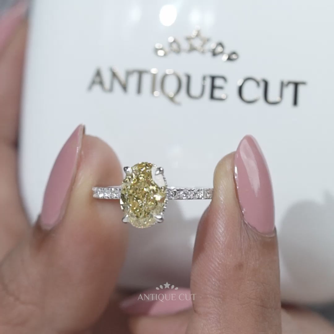 Ring with a yellow diamond and smaller diamonds on a gradient background

