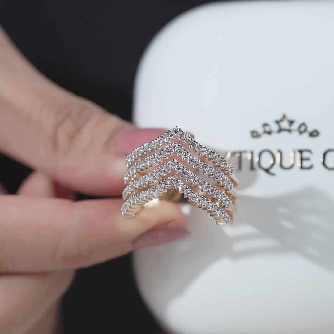 Gold and diamond chevron ring on a light background
