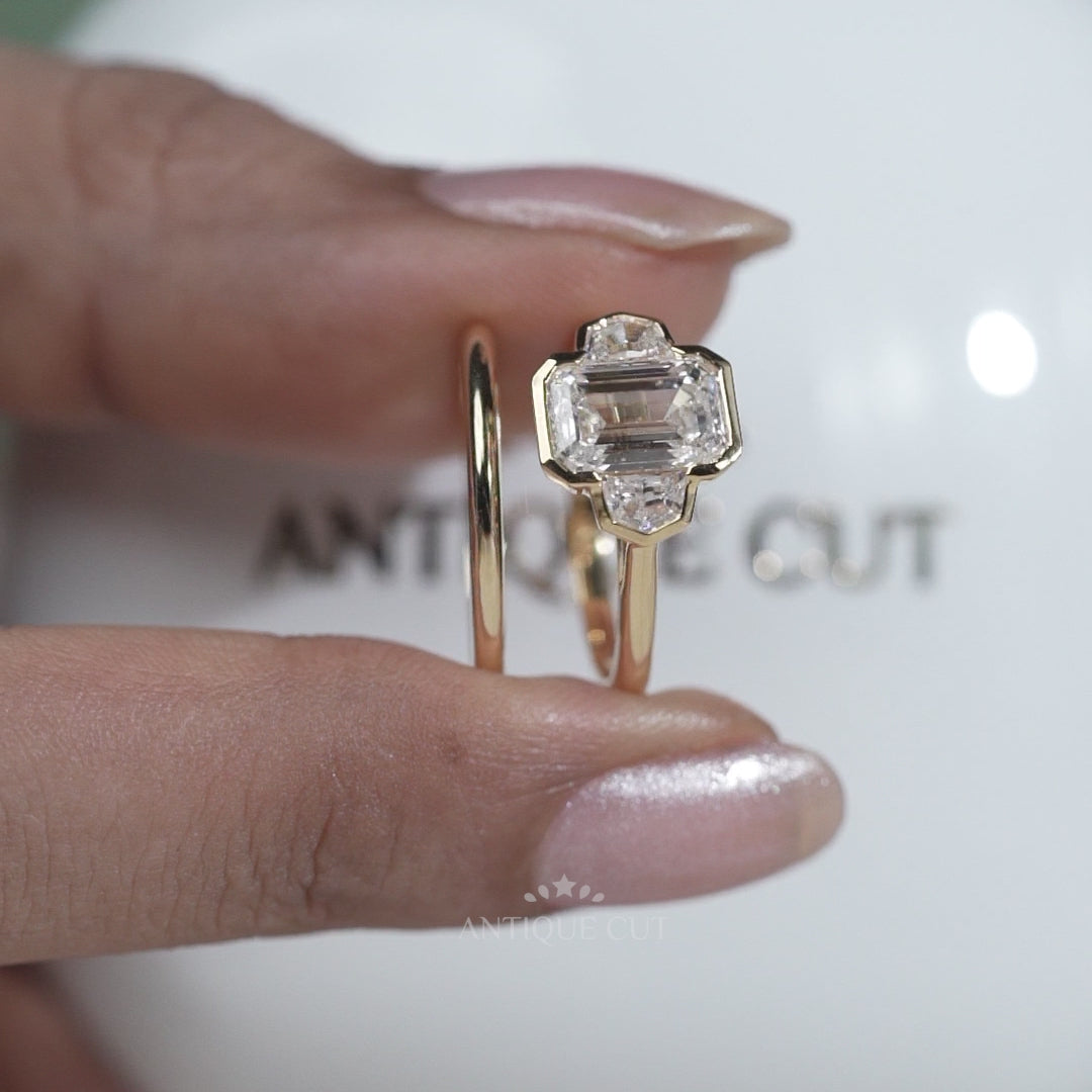 Gold ring with a large central diamond and smaller diamonds on a light gray background

