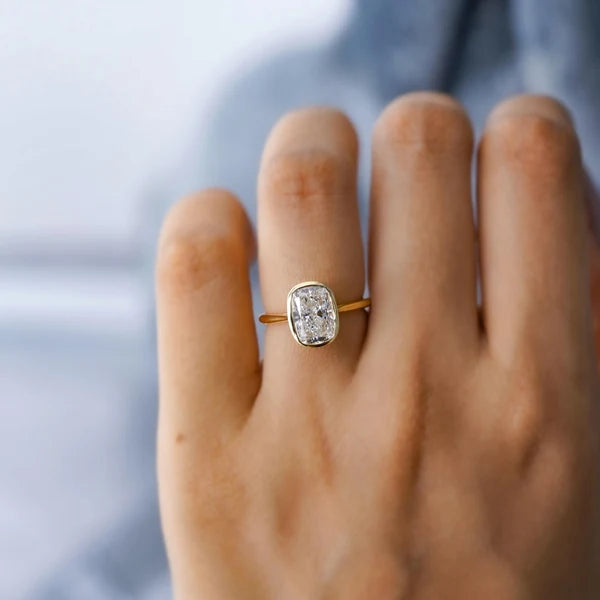 Yellow gold cushion diamond solitaire ring with bezel setting