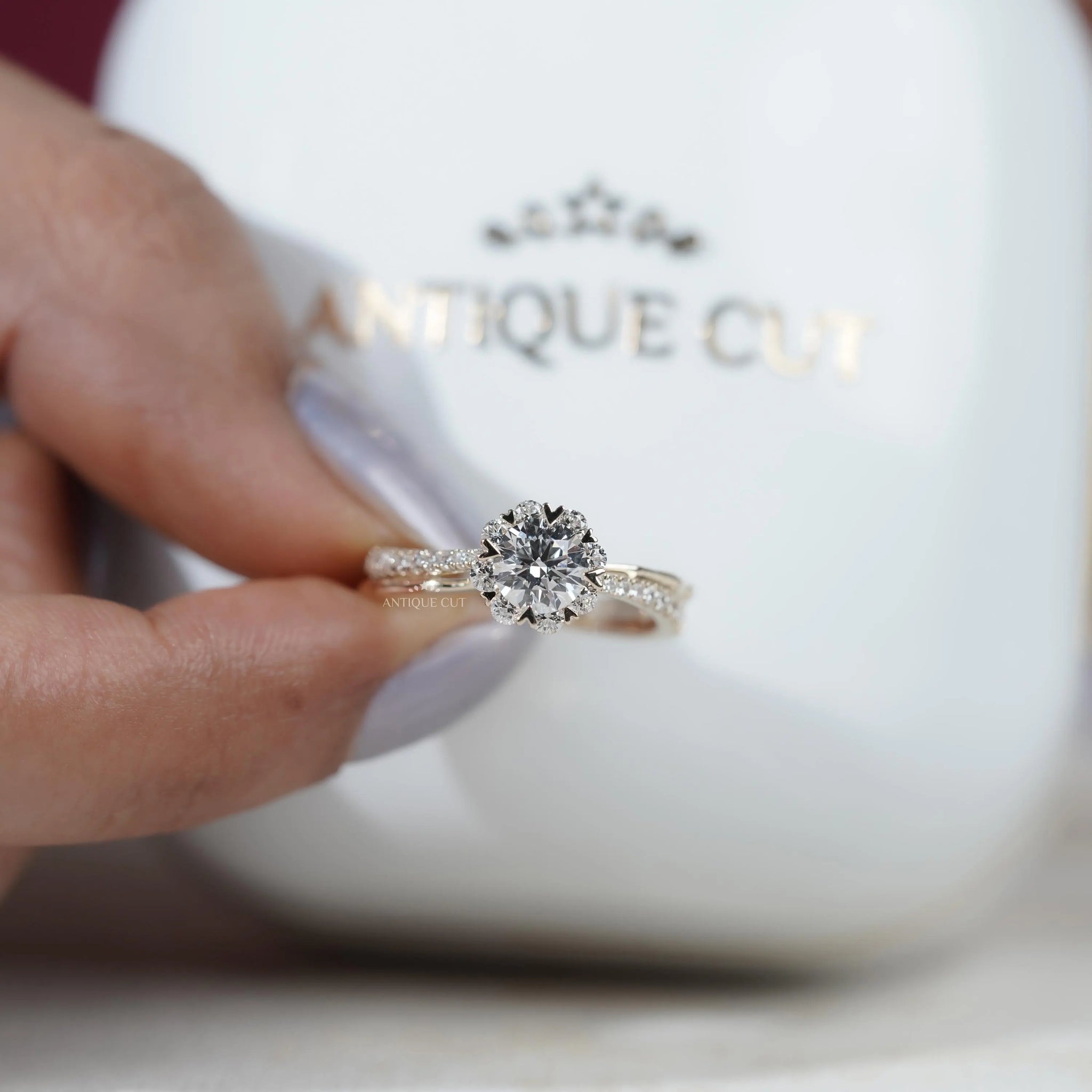 Round cut engagement ring with heart shaped prongs and pavé split shank
