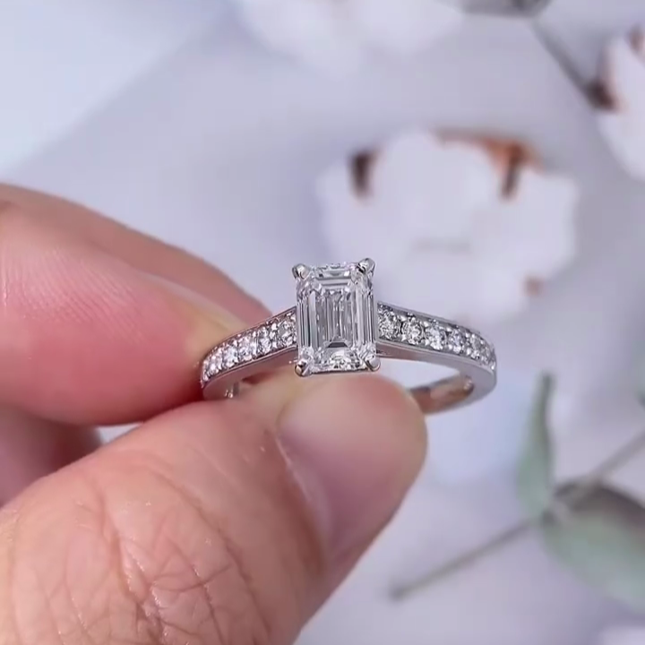 Rectangular emerald cut diamond solitaire ring with diamond accents