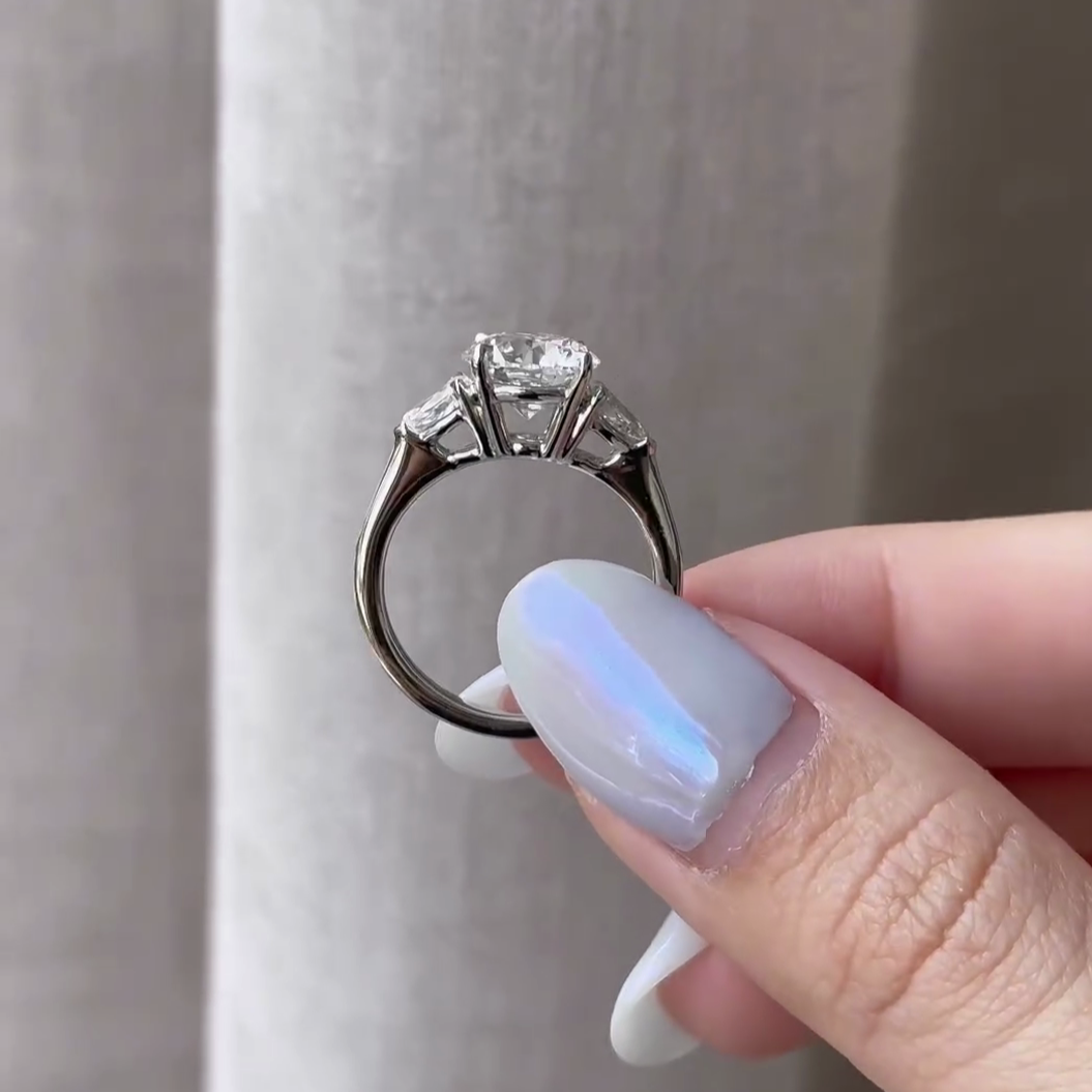 bridal round diamond ring with pear side stone setting